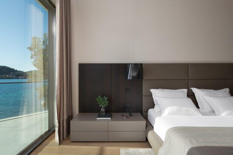 Schlafzimmer mit Kingsize-Bett und Meerblick von der Decke bis zur Decke in der Villa Anthon