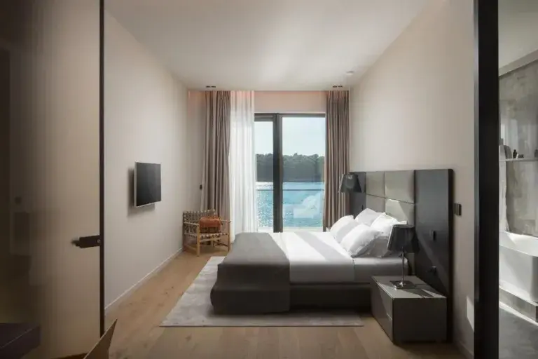 Bedroom with king-size bed and sea-view window at Villa Anthon