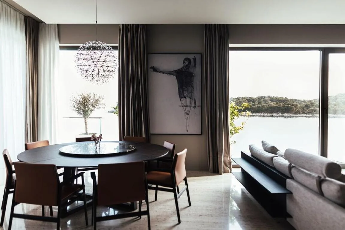 Round dining table and sofa with sea view at Villa Anthon