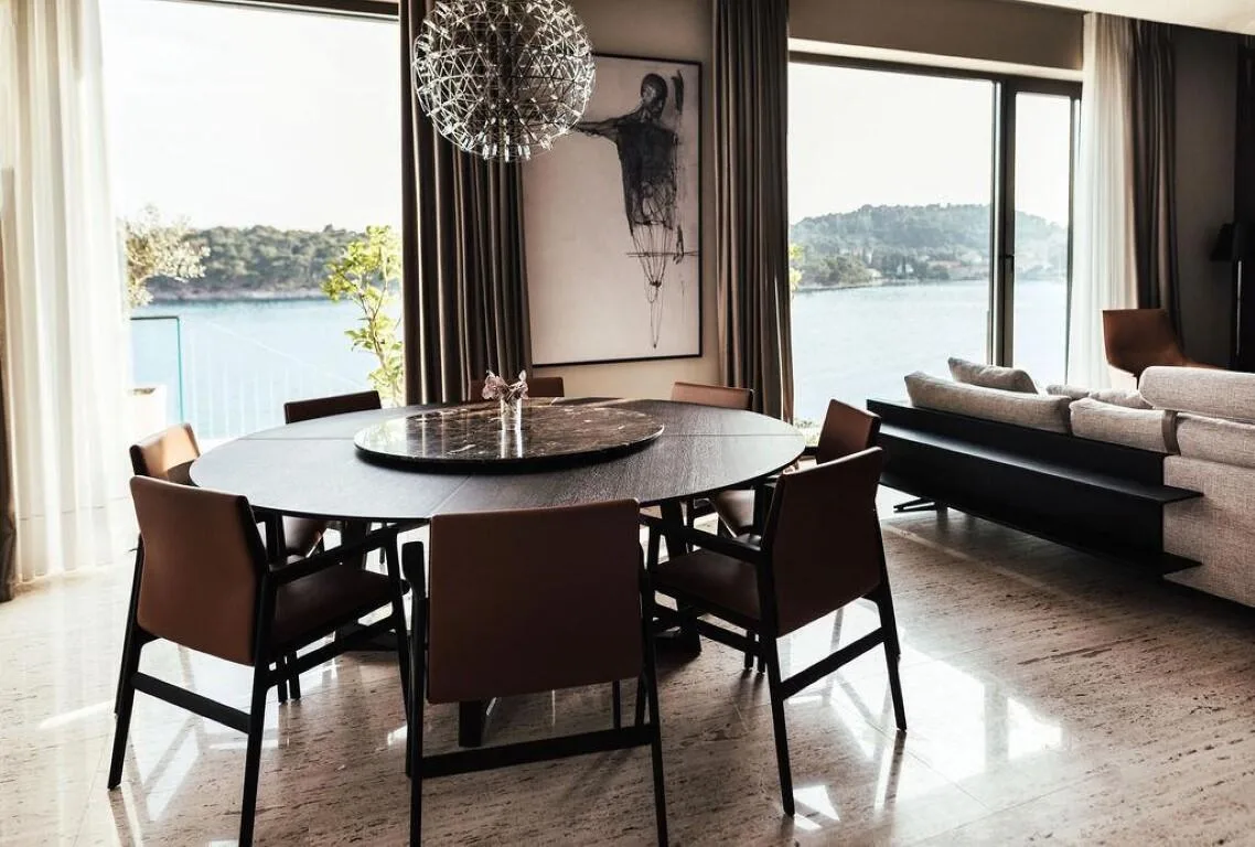 Dining table under a designer chandelier with sea views at Villa Anthon