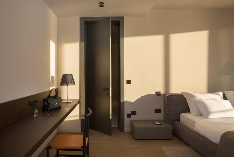 Schlafzimmer mit Bett und Schreibtisch in warmem Licht in Villa Anthon
