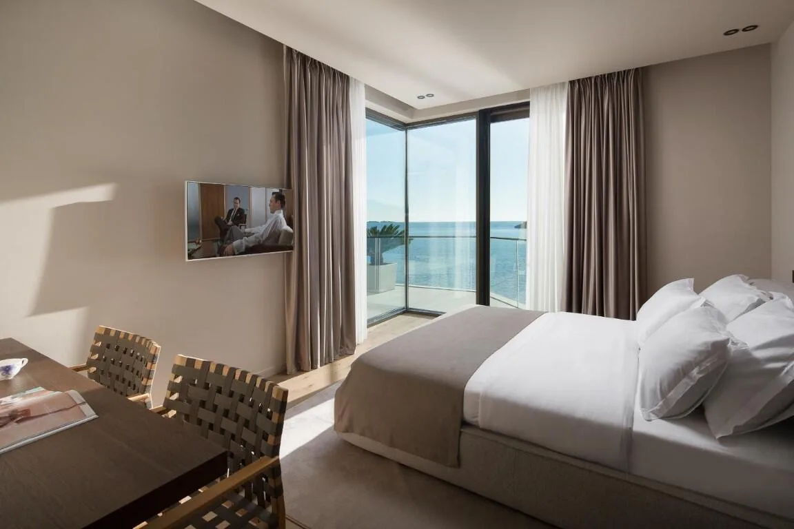Bedroom with bed, desk and sea-view windows at Villa Anthon