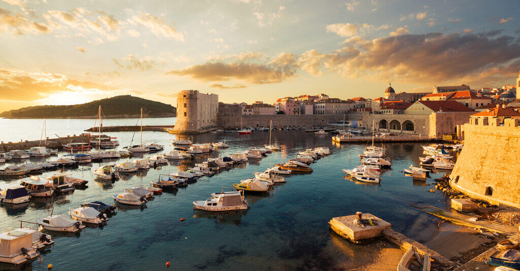 Die Altstadt von Dubrovnik mit ihrem Hafen und den Stadtmauern bei Sonnenuntergang