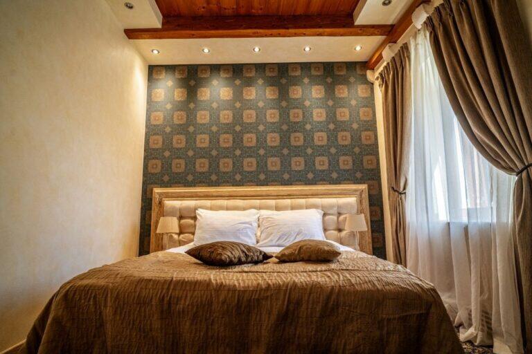 Schlafzimmer mit Kingsize-Bett und gemusterten Wänden im Villa Revelin