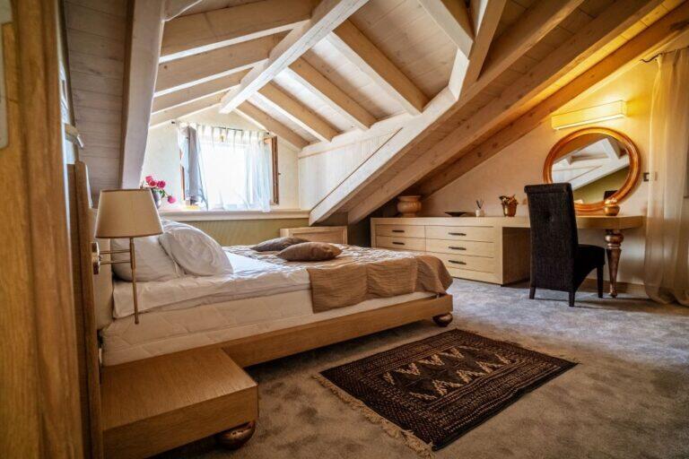 Attic-Schlafzimmer mit Kingsize-Bett und Schreibtisch in der Villa Revelin