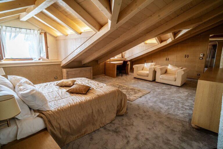 Schlafzimmer mit Kingsize-Bett und Sesseln in der Villa Revelin
