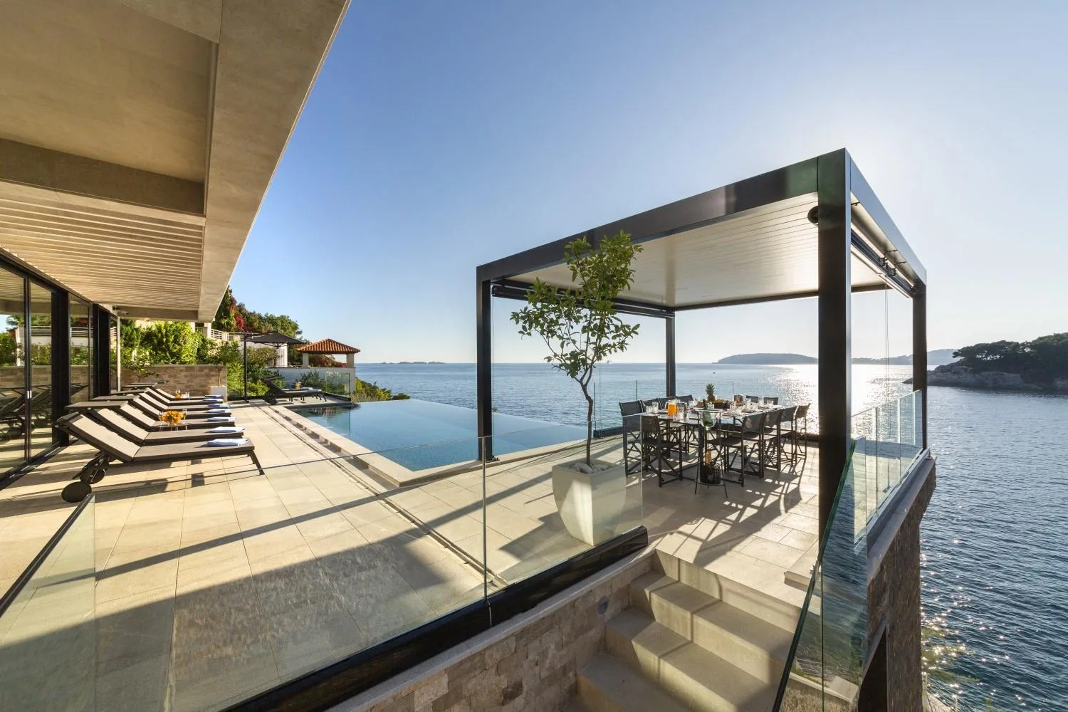 Sunset dining terrace with pergola and sea views at Villa Attis