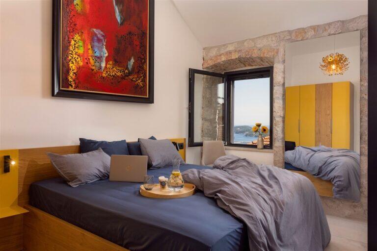 Schlafzimmer mit Kingsize-Bett und farbenfrohen Kunstwerken in der Villa MaR