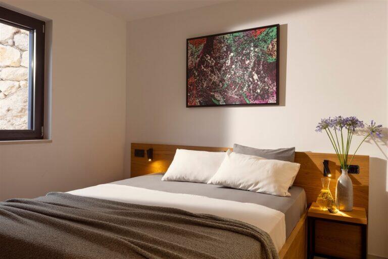Schlafzimmer mit Kingsize-Bett und Gemälde in der Villa MaR