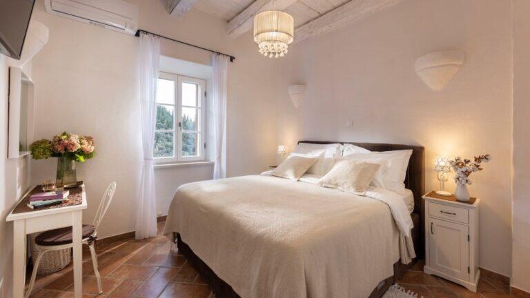Schlafzimmer mit Kingsize-Bett und Kronleuchter in der Villa Molunat