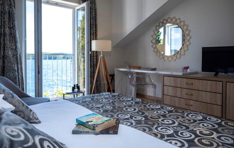 Schlafzimmer mit Queensize-Bett und Fenster mit Meerblick im Five Bedroom Resort Villa