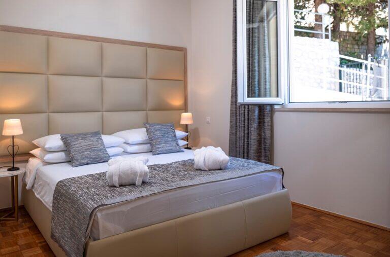 Schlafzimmer mit Queensize-Bett und gepolstertem Kopfteil in der Five Bedroom Resort Villa