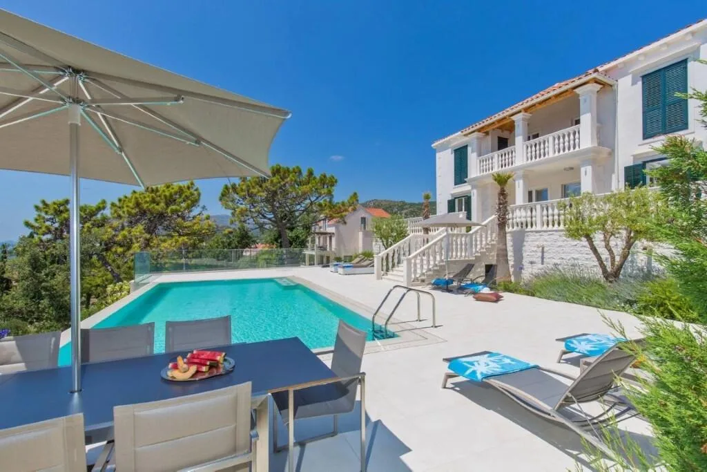 Outdoor dining table and parasol beside the pool at Villa Vintage