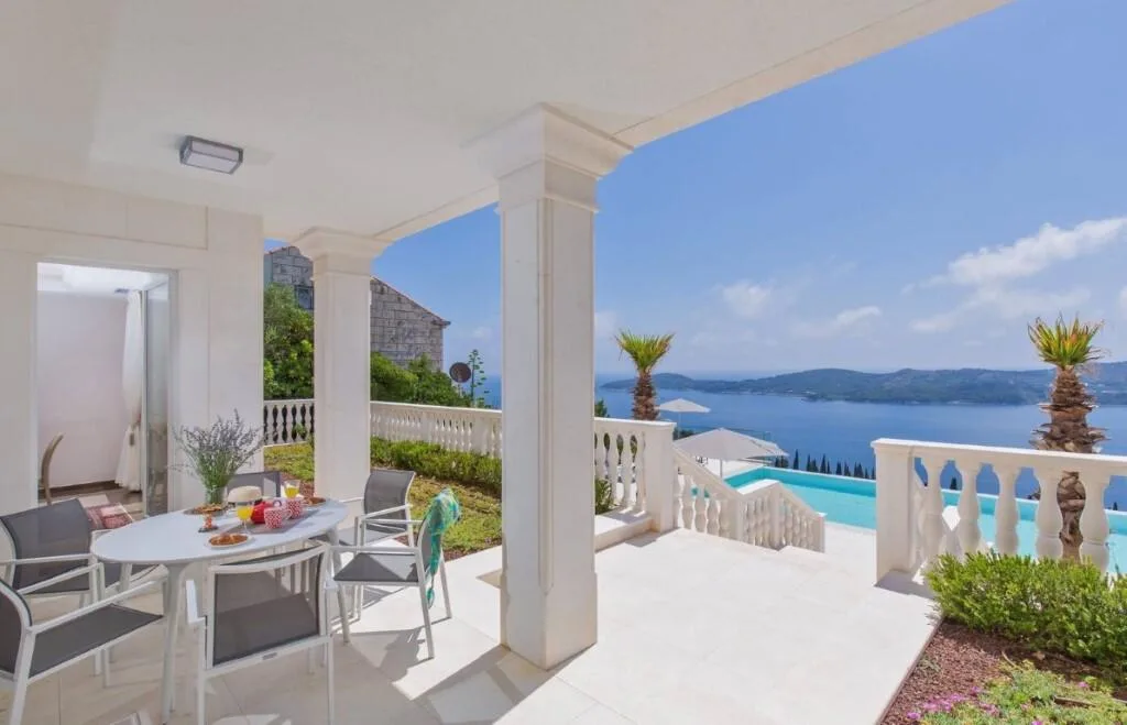 Covered terrace with dining set and sea view at Villa Vintage