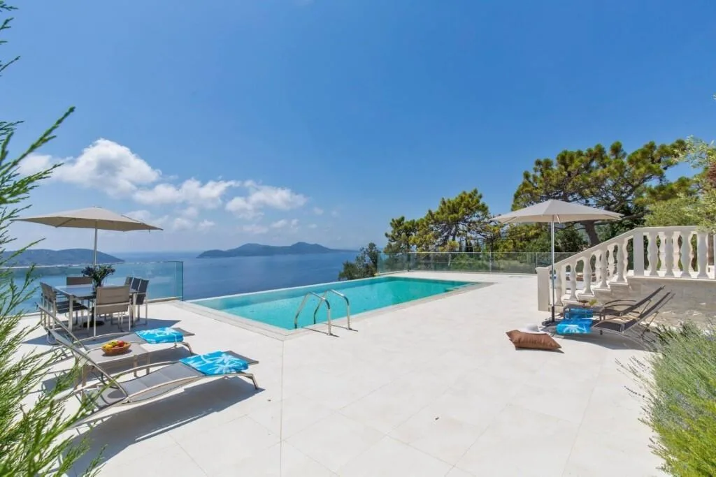 Sun loungers by the pool with sea views at Villa Vintage