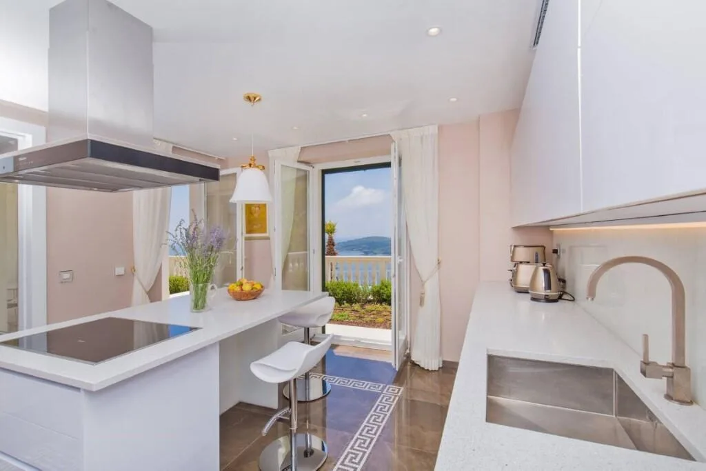 White kitchen with sea-view window at Villa Vintage