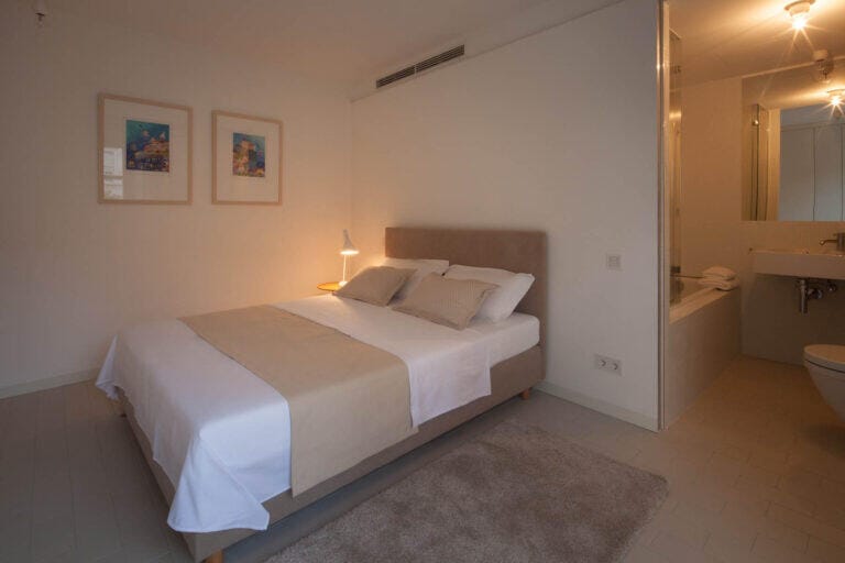 Schlafzimmer mit Kingsize-Bett und eigenem Badezimmer in der Villa Oasis