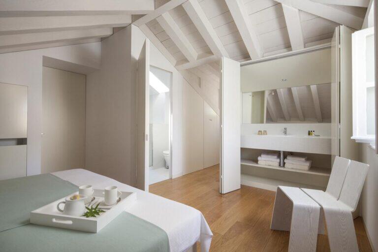 Schlafzimmer mit Frühstückstisch und offener Badezimmeranlage in der Villa Oasis