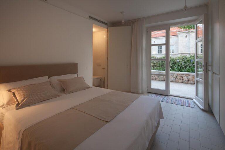 Schlafzimmer mit Queensize-Bett und Gartentür in der Villa Oasis