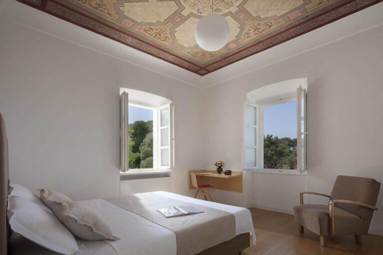 Schlafzimmer mit Kingsize-Bett und gestrichenem Deckenfries in der Villa Oasis