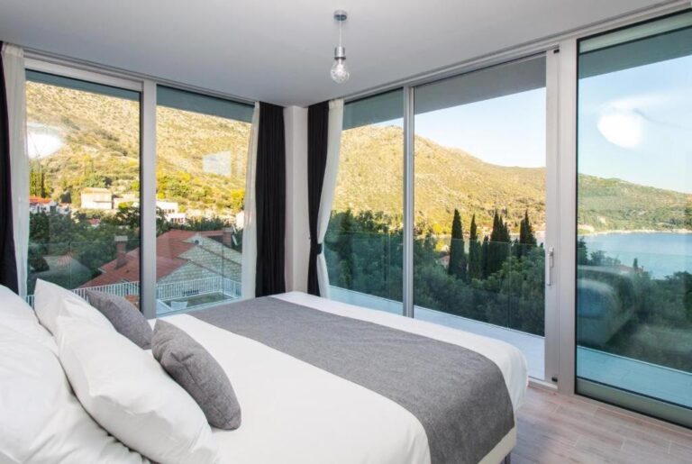 Schlafzimmer mit Kingsize-Bett und bodentiefe Fenster im Villa Art