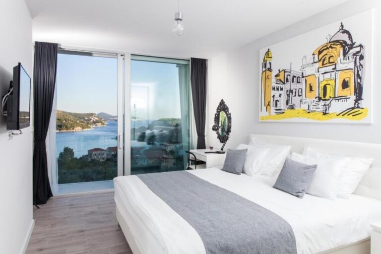 Schlafzimmer mit Kingsize-Bett und Fenster mit Meerblick in der Villa Art