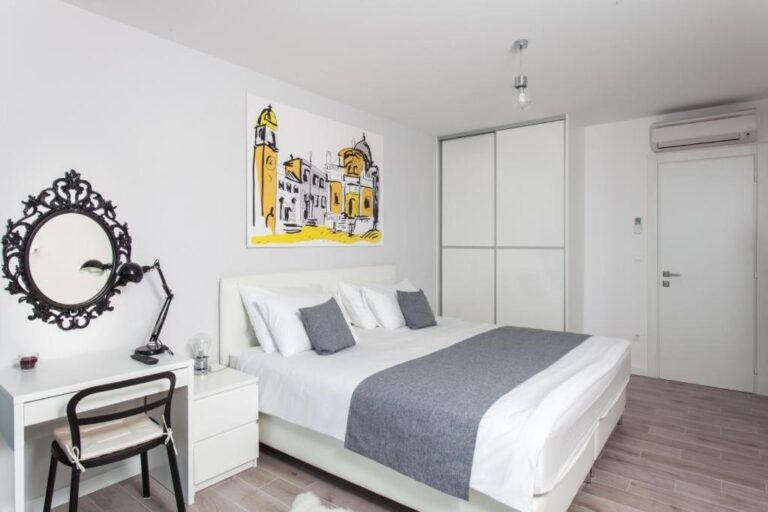 Schlafzimmer mit Kingsize-Bett, Schreibtisch und Kunstwerken in der Villa Art
