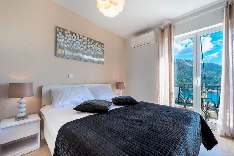Bedroom with queen-size bed and balcony with sea view at House T