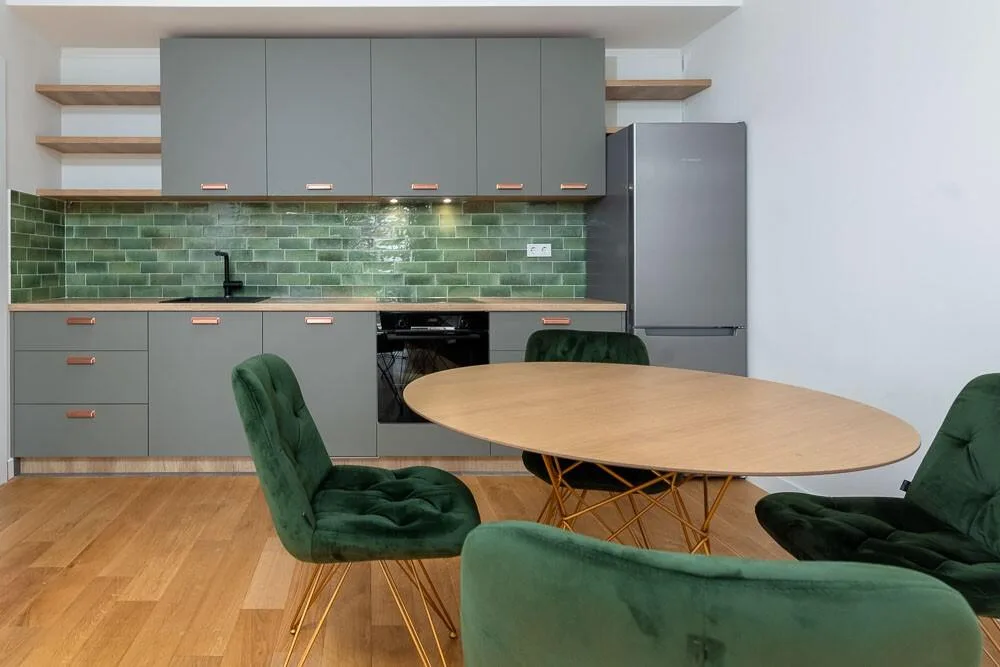 Kitchen with green tiles and round dining table in the annex at Villa La Rose