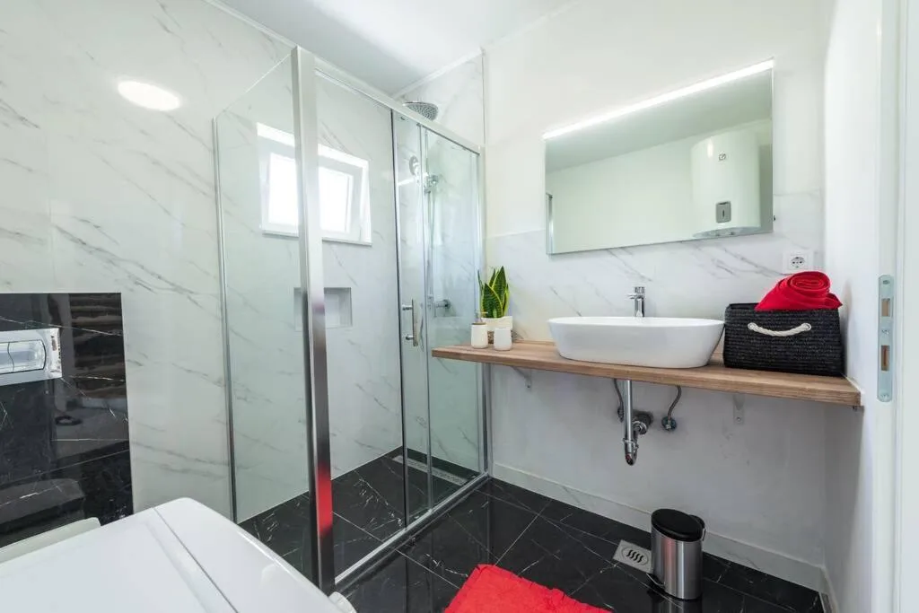 Salle de bains avec douche en verre et carreaux de marbre à House Maure