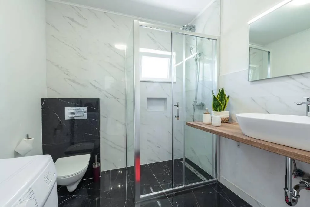 Salle de bains avec lavabo de forme de vaisseau et douche à l’italienne à House Maure