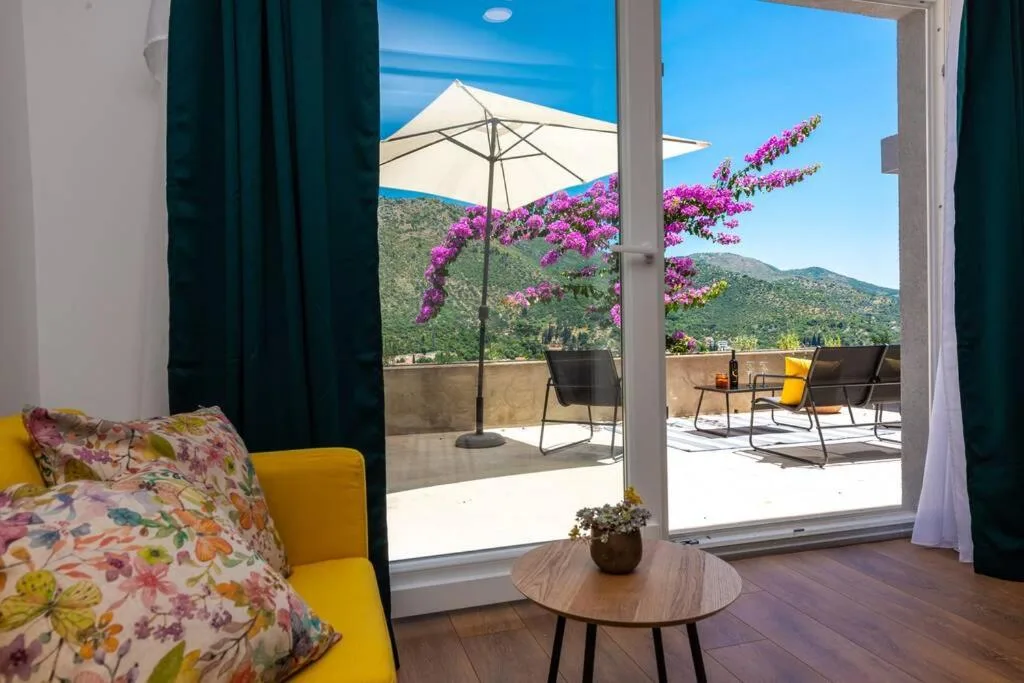 Chaire avec des portes vitrées donnant sur une terrasse avec des bougainvillées à la House Maure