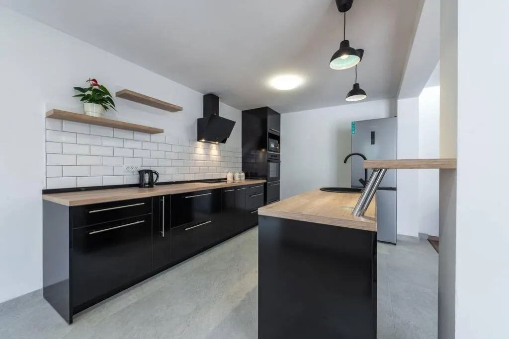 Cuisine avec comptoir en bois et armoires noires à House Maure