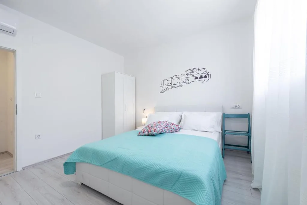 Chambre à coucher avec un couvre-lit turquoise et un placard à House Maure