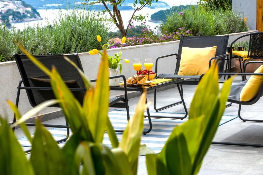 Terrasse avec des chaises et des boissons donnant sur la baie à House Maure