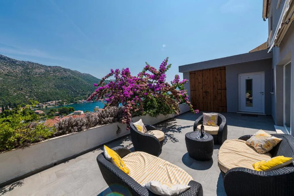Salon de terrasse avec des canapés en rotin et des bougainvillées à House Maure