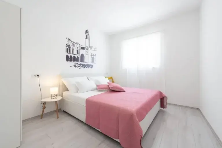 Chambre à coucher avec un lit king-size et des draps roses à la House Maure