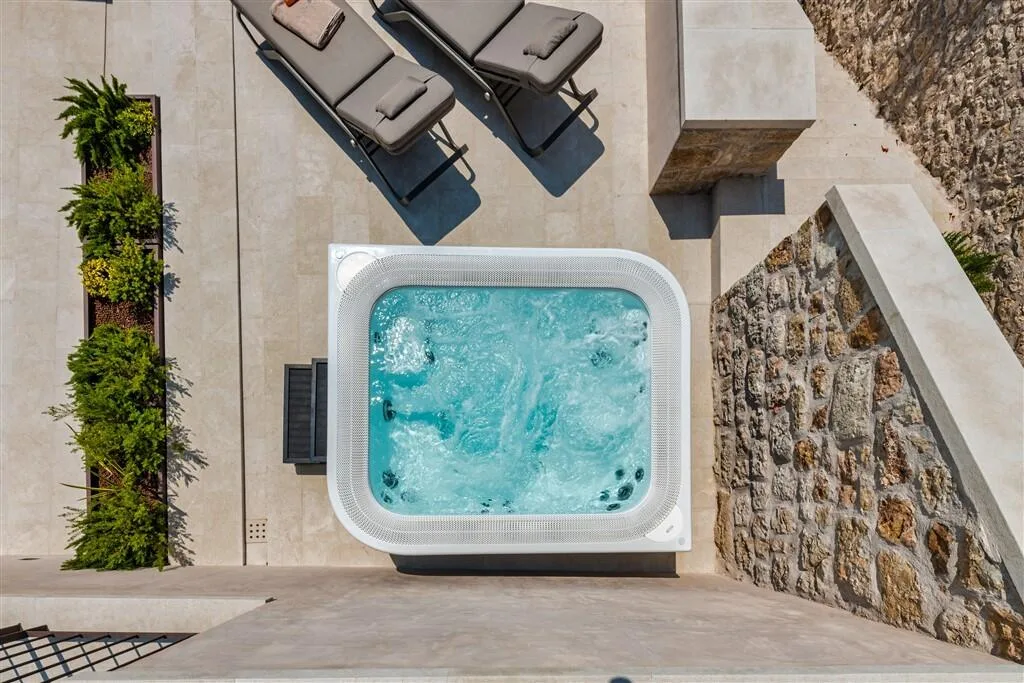Outdoor hot tub beside a green wall at Villa La Rose, aerial view