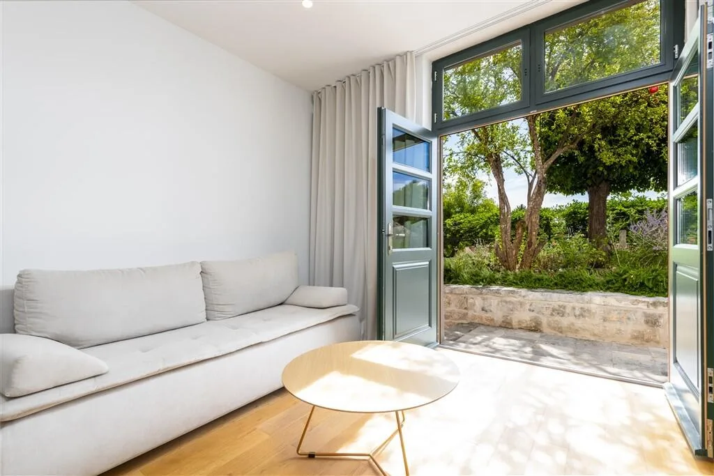 Bright sitting room opening onto the garden terrace at Villa La Rose