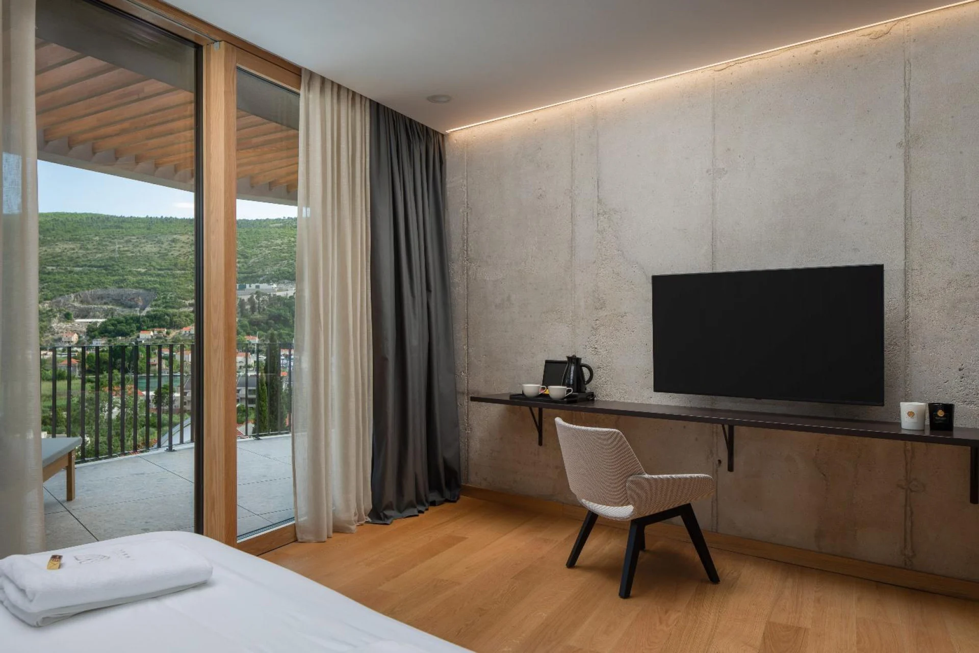 Bedroom with desk and TV with balcony at Villa Palazzo