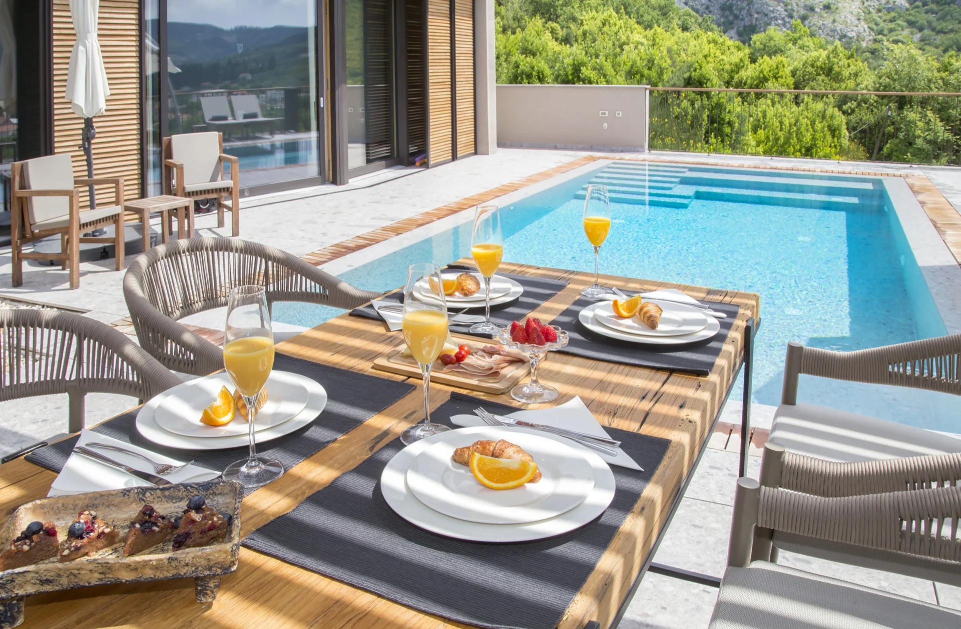Breakfast table by the pool at Villa Palazzo