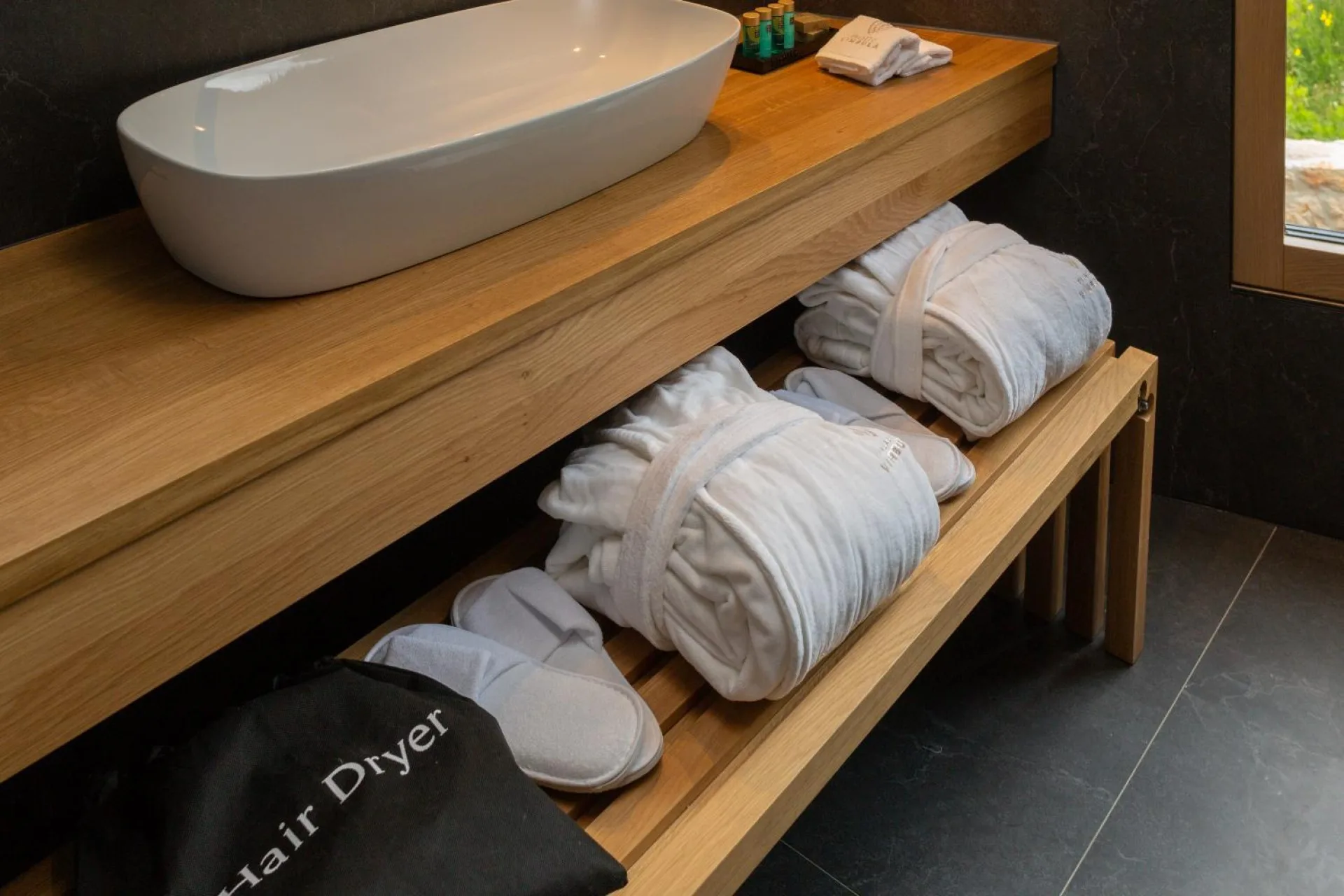 Bathrobes and towels on a wooden shelf at Villa Palazzo