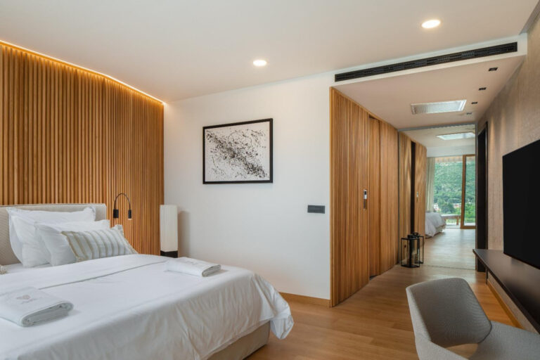 Schlafzimmer mit Kingsize-Bett und Holzwand im Villa Palazzo