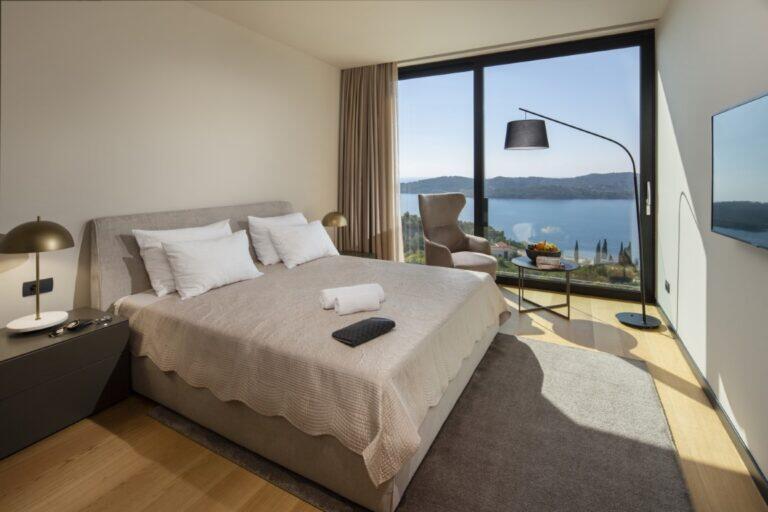 Schlafzimmer mit Kingsize-Bett und Sessel in der Villa Elena