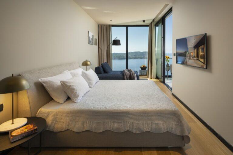 Schlafzimmer mit Kingsize-Bett und Fernseher mit Meerblick in der Villa Elena