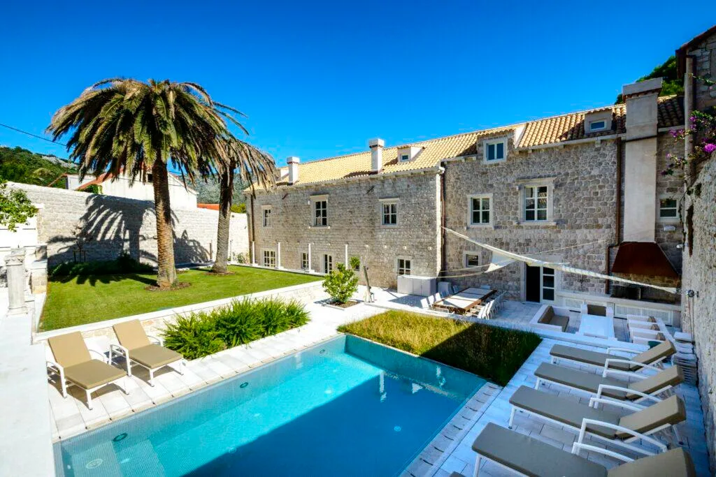 Pool and stone estate with palm trees at Villa Carpe Diem in Zaton