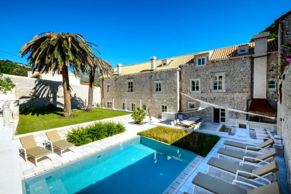 Pool and stone estate with palm trees at Villa Carpe Diem in Zaton