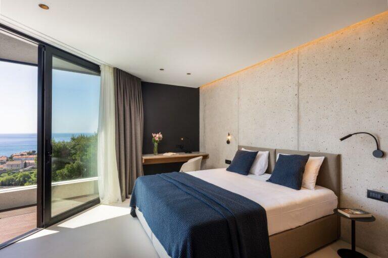 Schlafzimmer mit Kingsize-Bett und Balkon mit Meerblick in der Villa Amari Monte