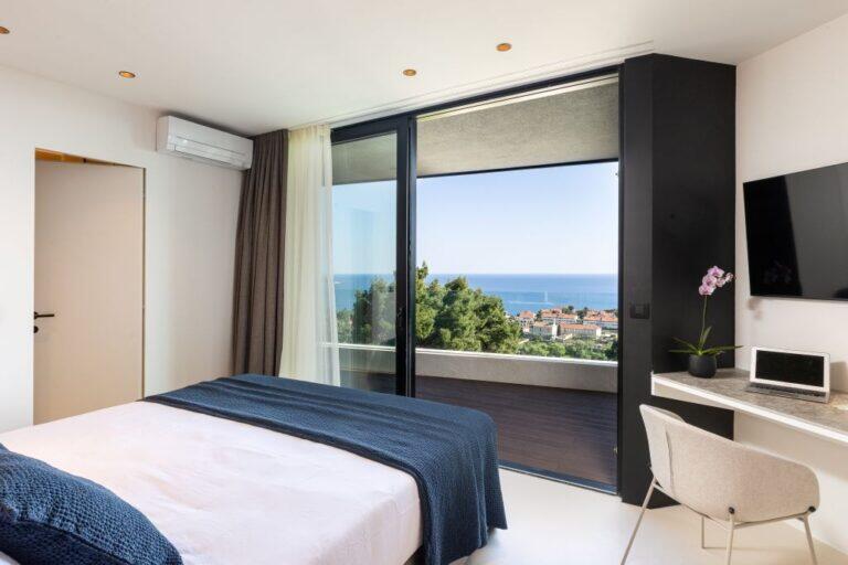 Schlafzimmer mit Kingsize-Bett und Balkontür im Villa Amari Monte