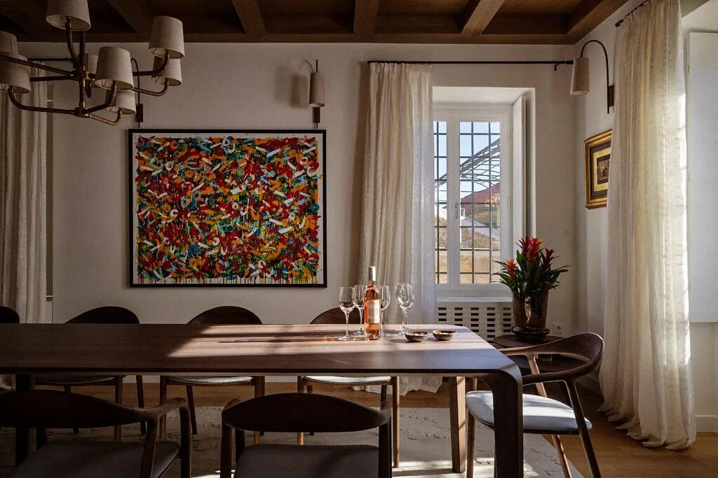 Dining table with colourful artwork and chandelier at Villa La Rose